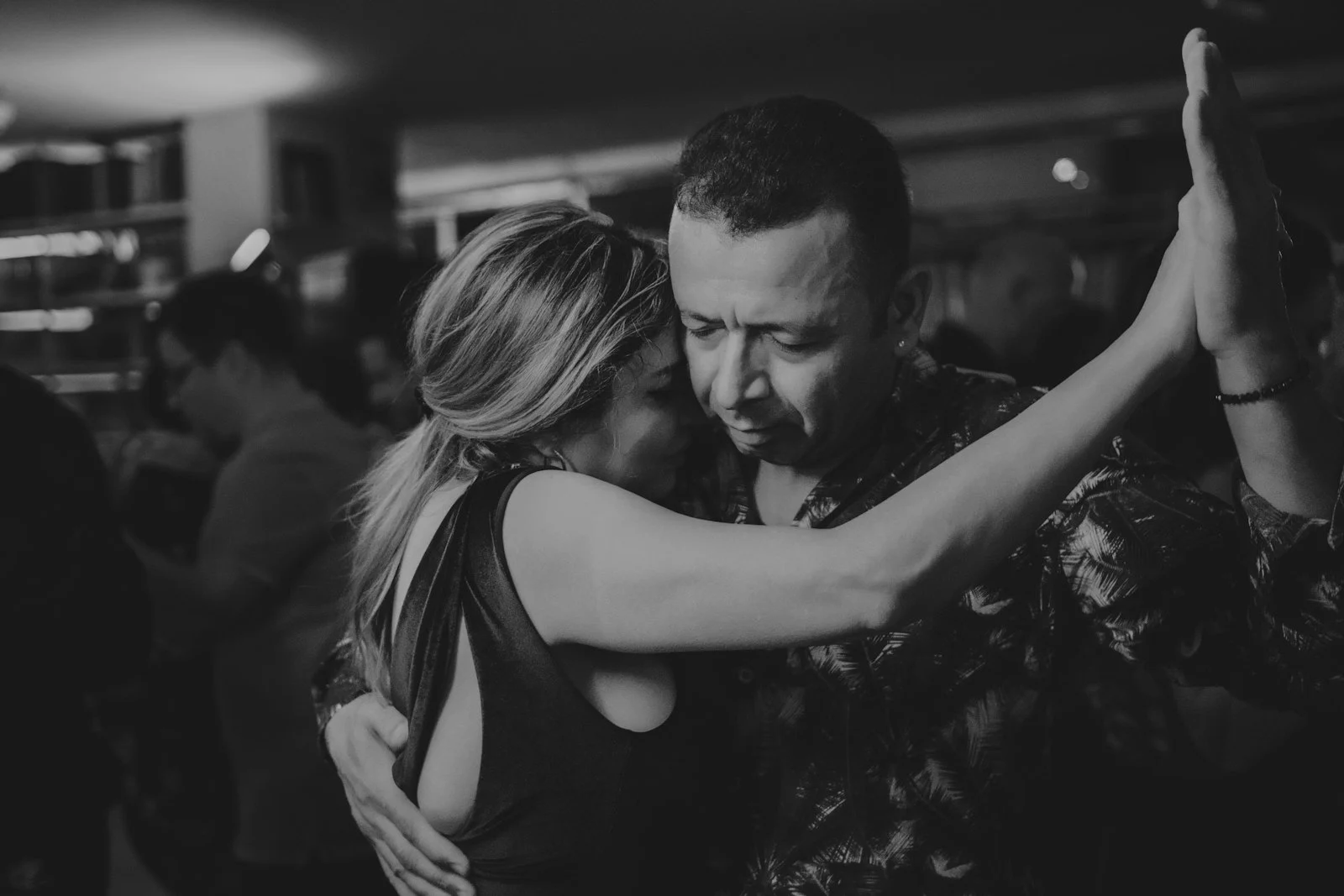 Pareja bailando zouk en sala poco iluminada